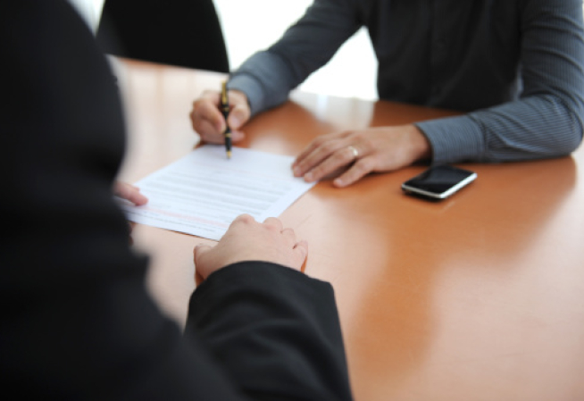 2 personnes signant un contrat 