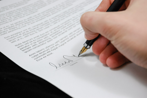 Photo gros plan d'un professionnel en train de signer un document